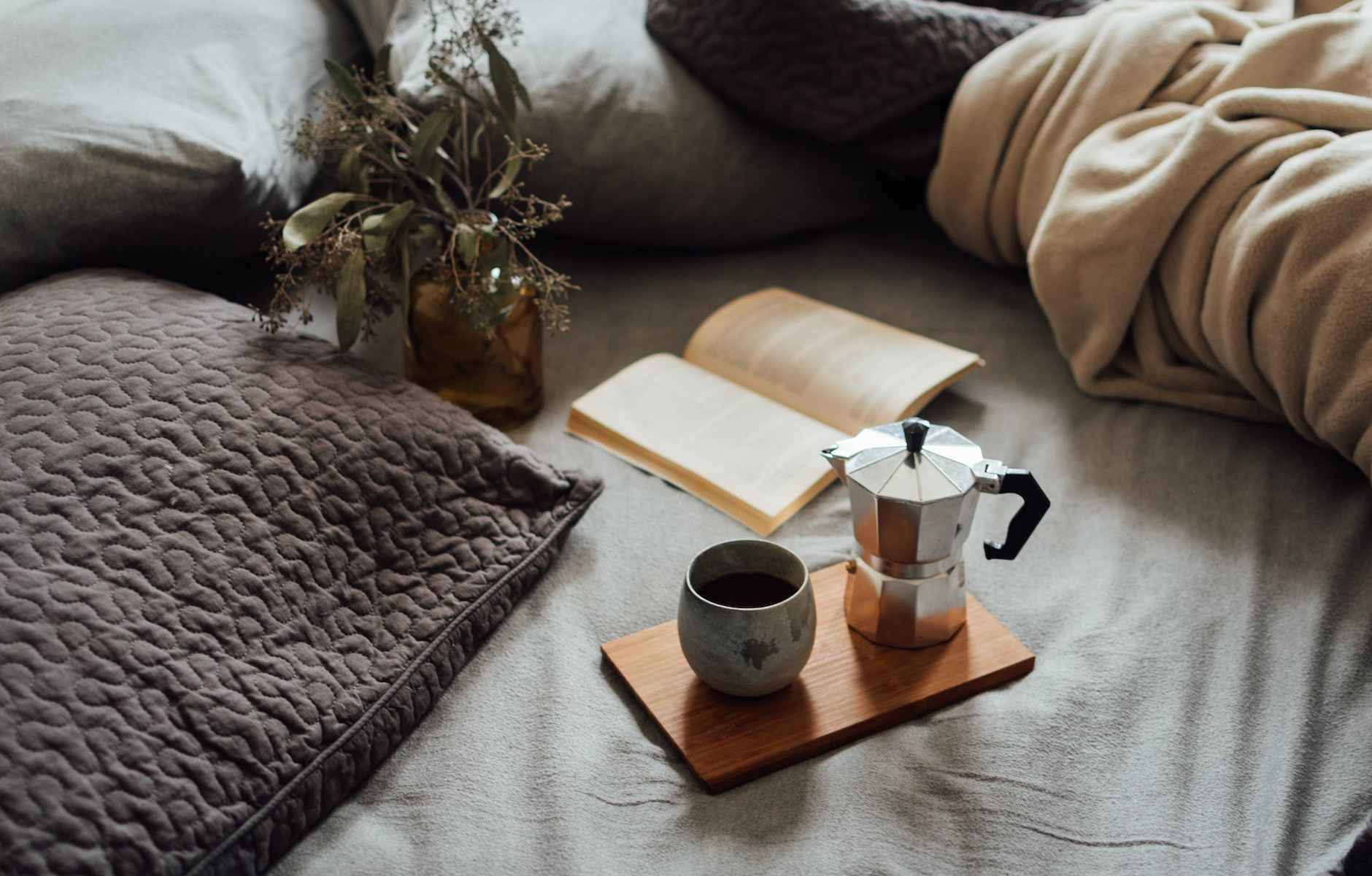 coffee and book on comfortable bed